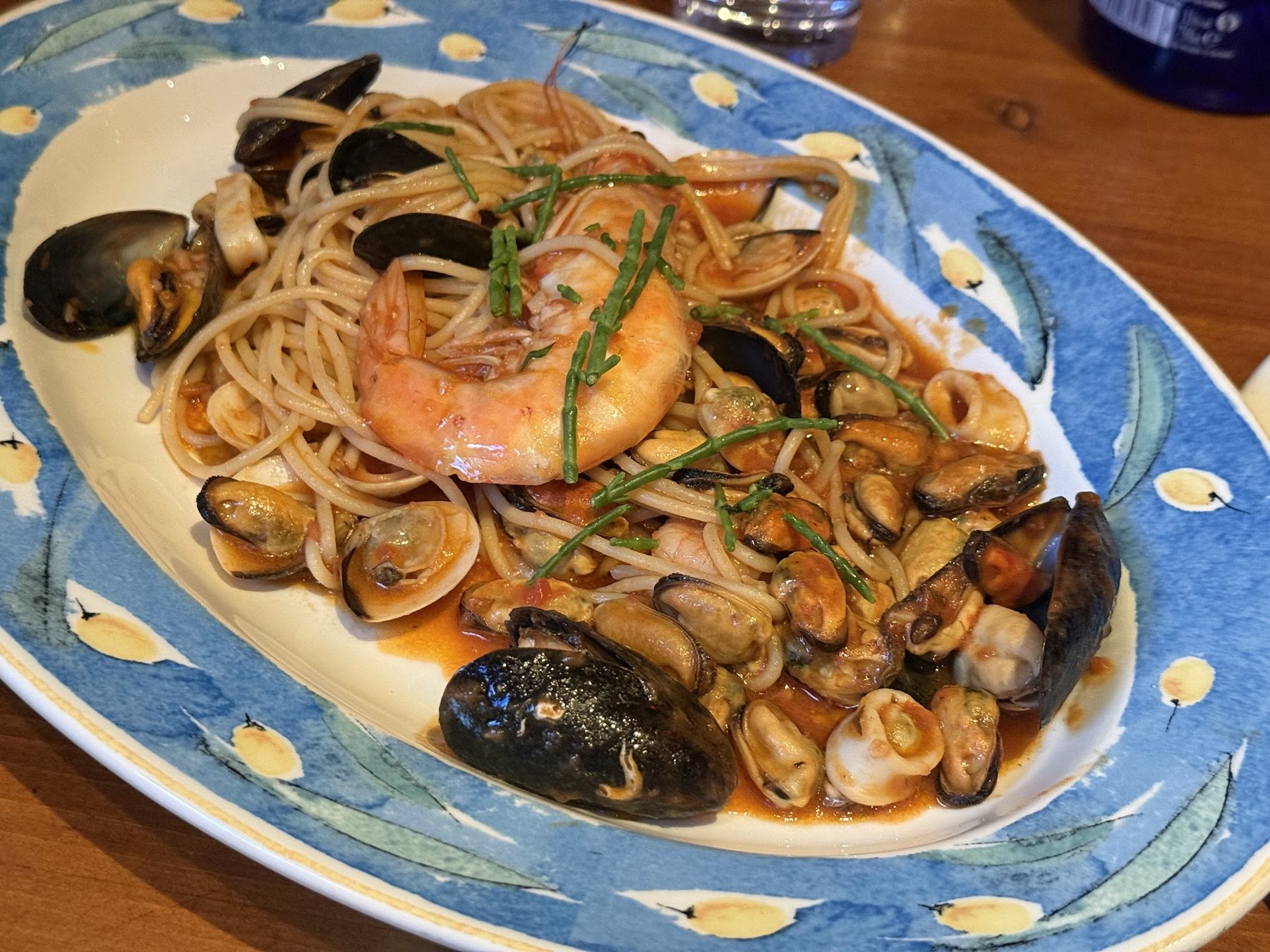 Seafood spaghetti with mussels, prawns and clams on a blue patterned plate
