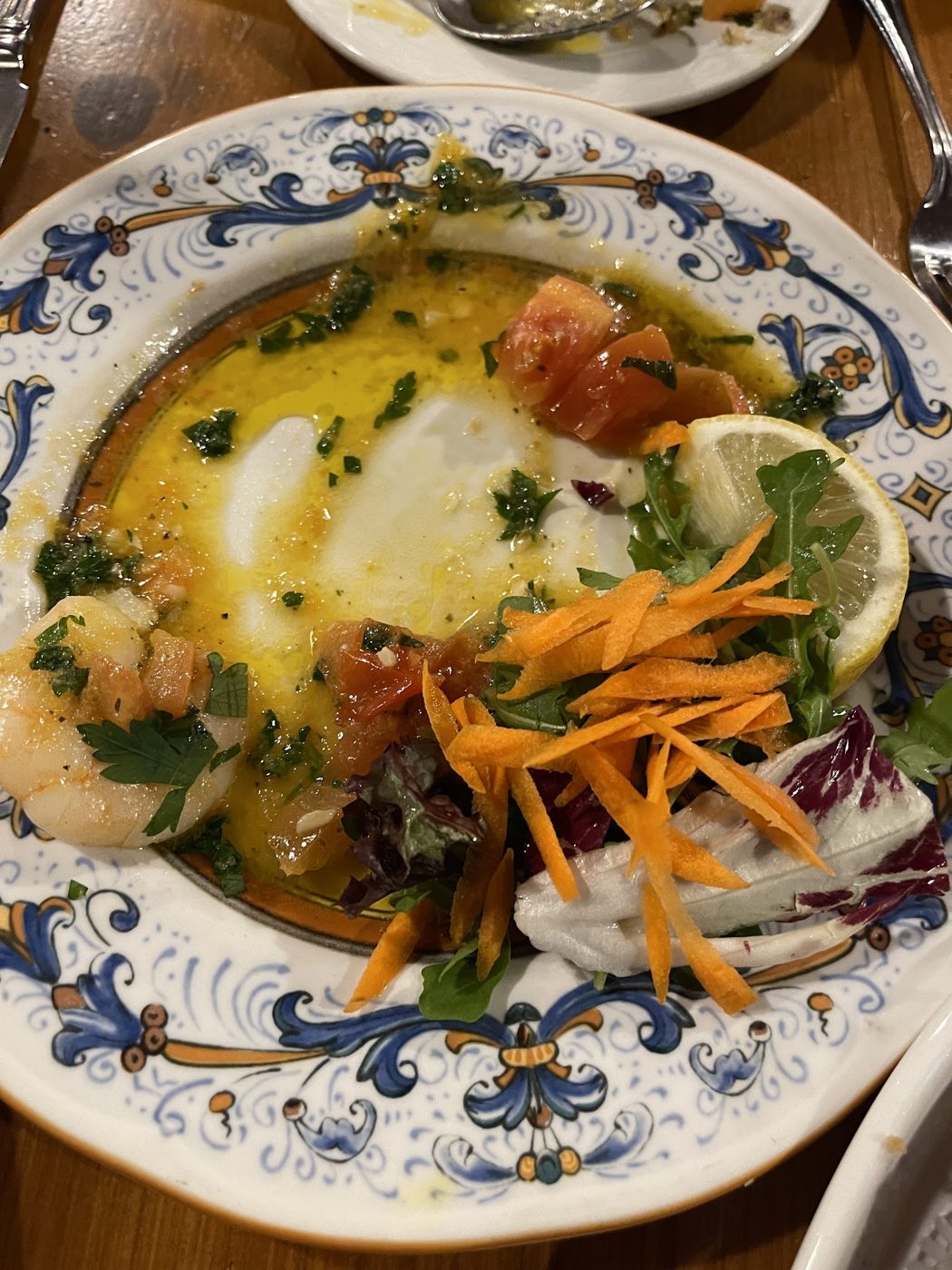 A vegetable dish with lemon and grated carrot on a painted plate