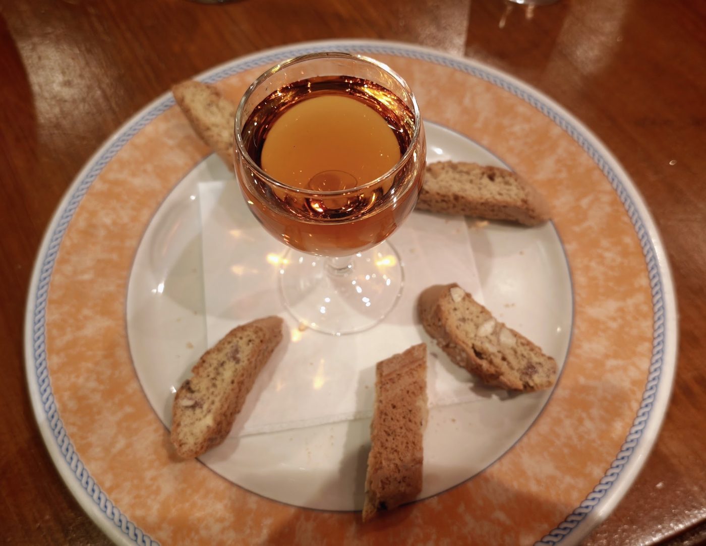A glass of dessert wine with cantucci biscuits
